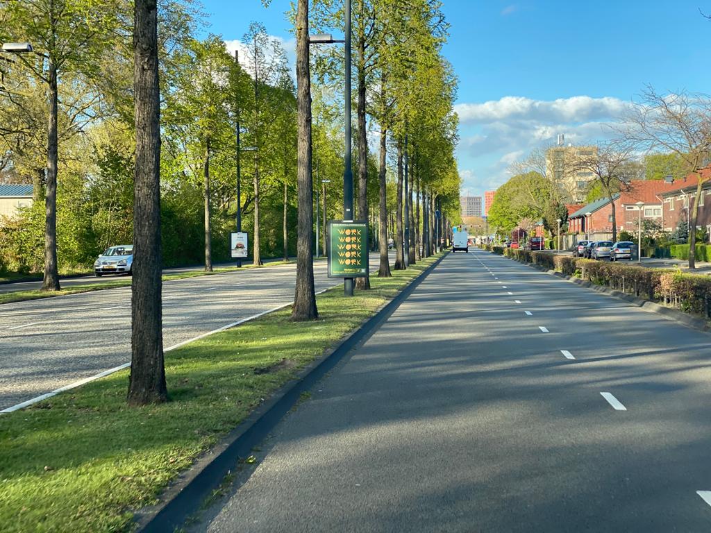 Straat met reclame bord McDonalds in middenberm